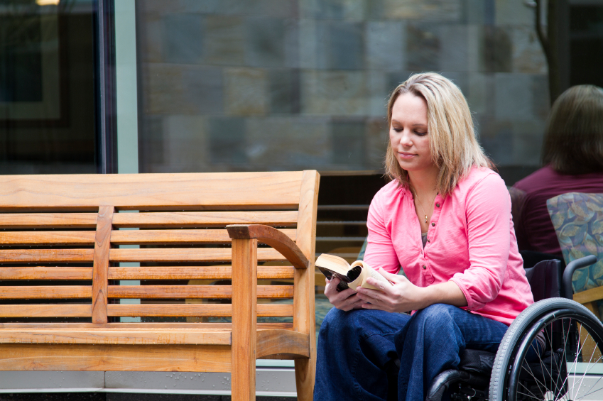 woman sitting near bench in wheelchair